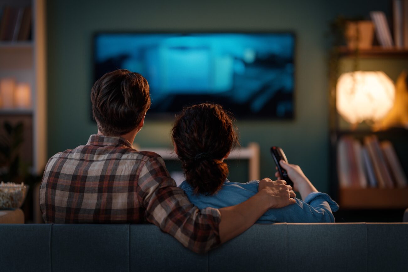 dva lidé se dívají na televizi 