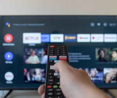 Člověk míří ovladačem na televizi.