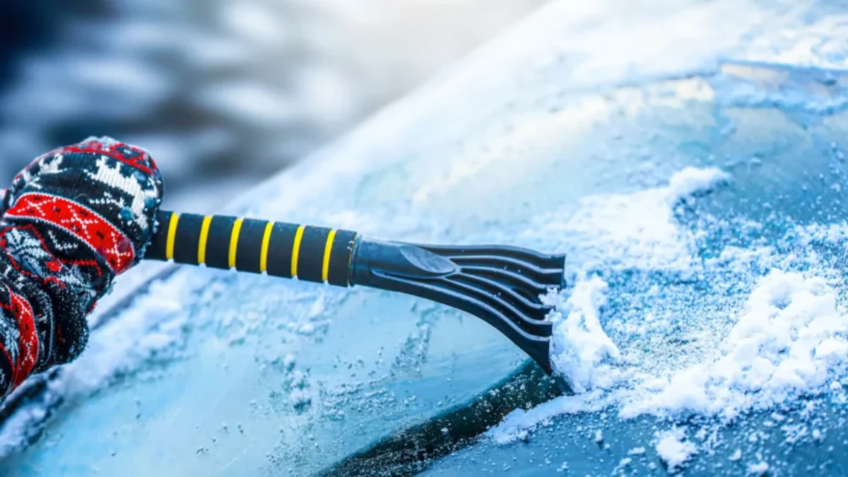 Seškrabávání námrazy z čelního skla.