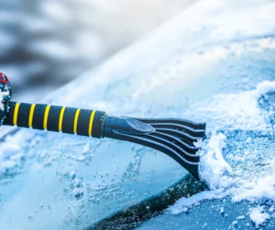 Seškrabávání námrazy z čelního skla.