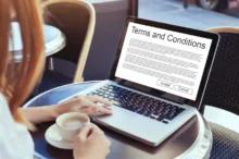 žena čte na notebooku terms and conditions webu