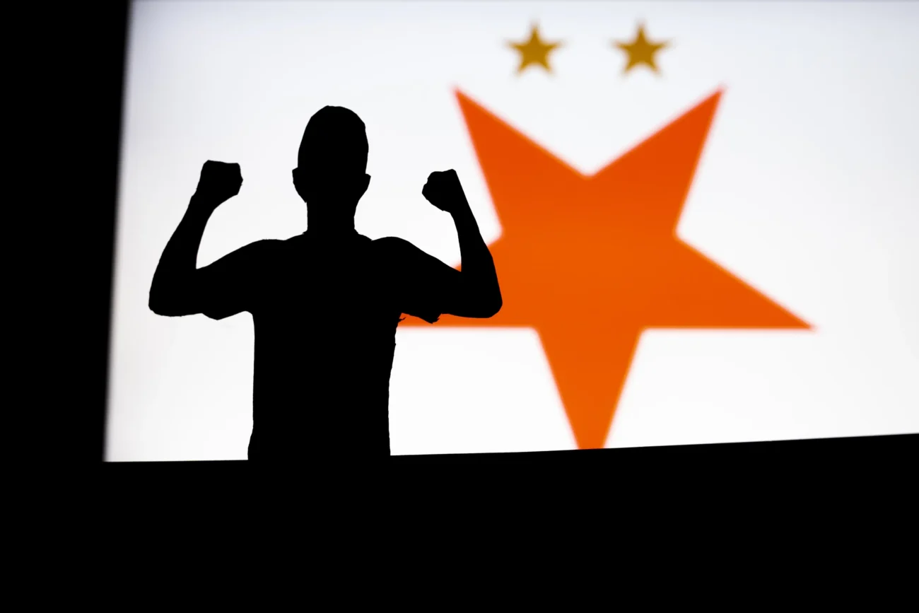 Muž stojí před logem Slavie.