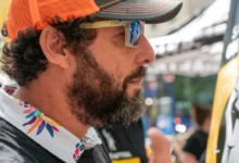 Adam Sandler se tváří vážně a má na sobě kšilt s brýlemi.