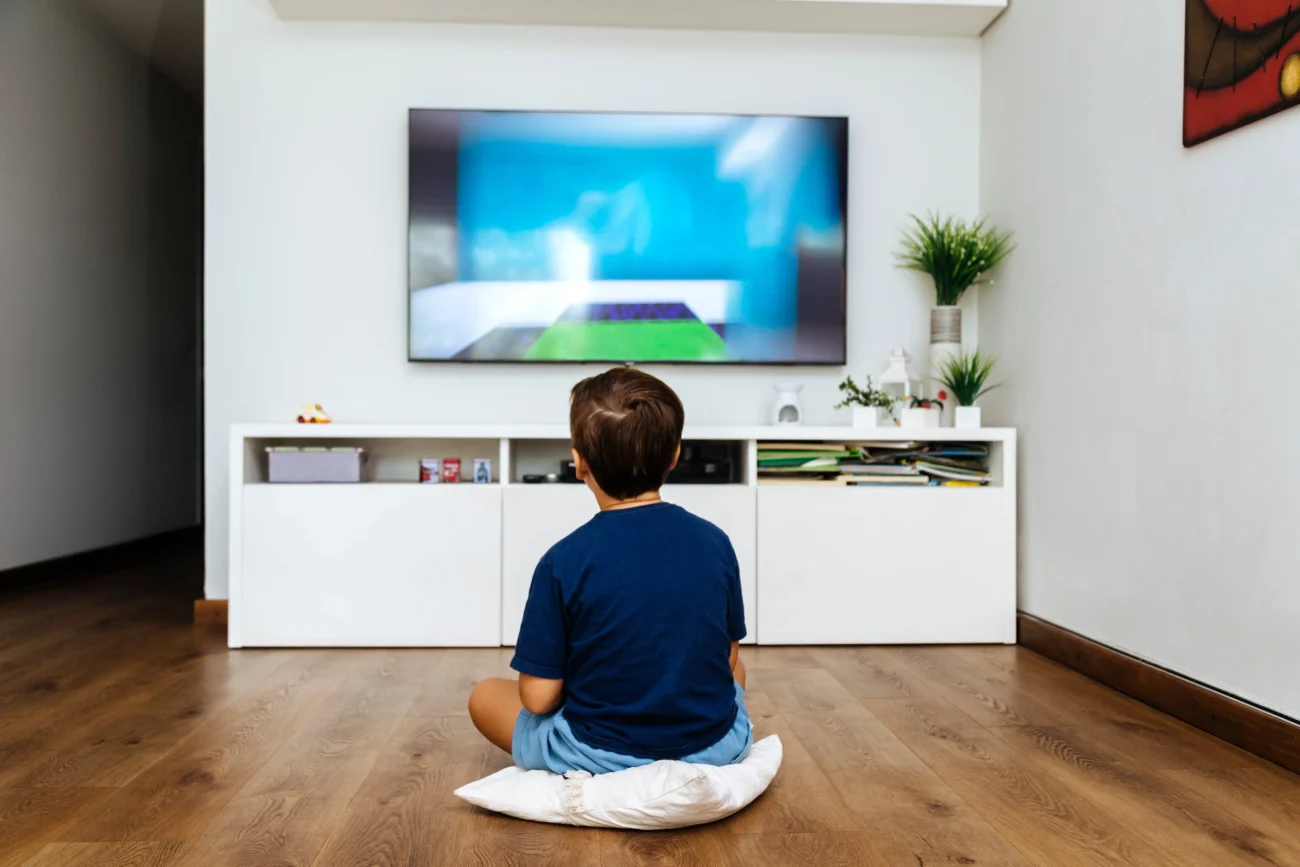 dítě sedící před televizí