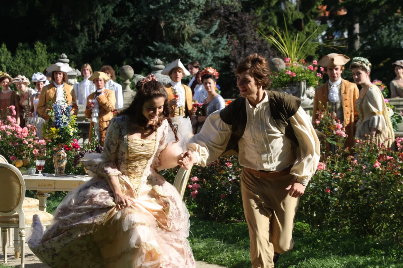 Princezna s princem společně probíhají mezi lidmi. 