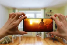 Člověk v ruce drží telefon, na kterém je puštěný hudební videoklip.