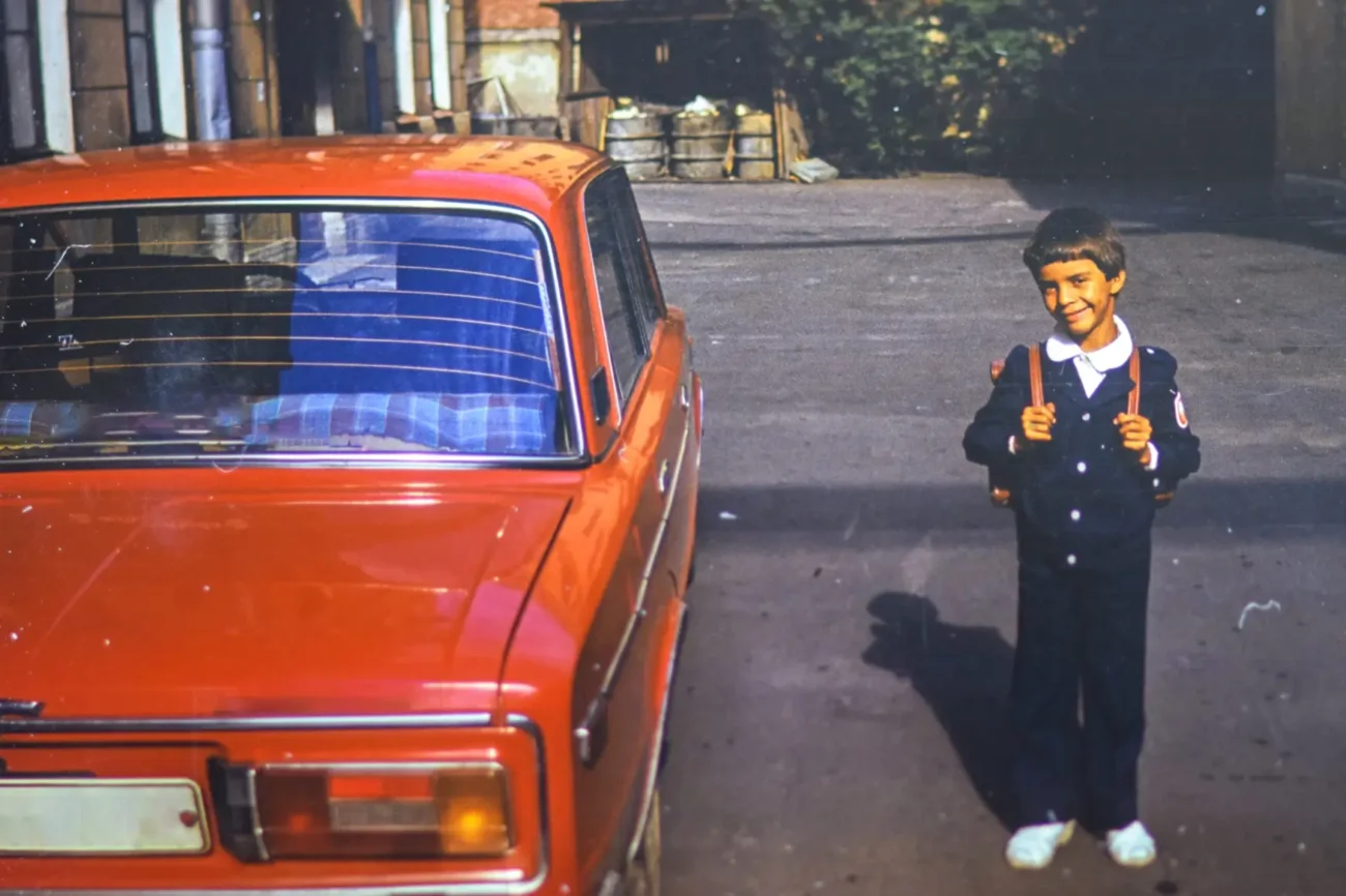 Chlapeček stojí vedle retro auta.