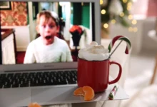 Na notebooku stojí hrnek s kakaem a hraje Sám doma.