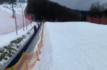 lidé jsou na horách na zasněženém kopci a jedou sáňkovat