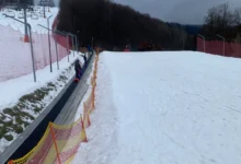 lidé jsou na horách na zasněženém kopci a jedou sáňkovat