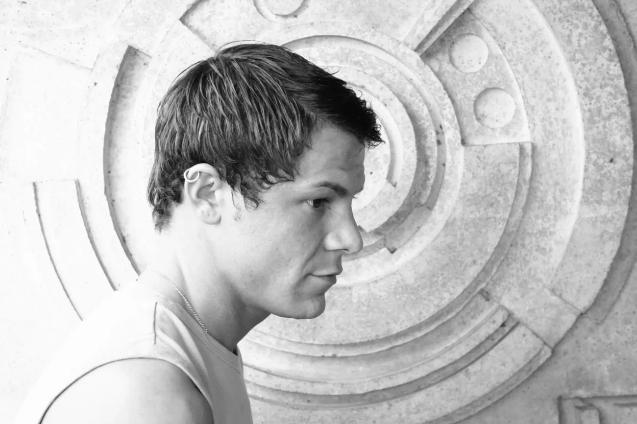 Muž stojí před portálem. 