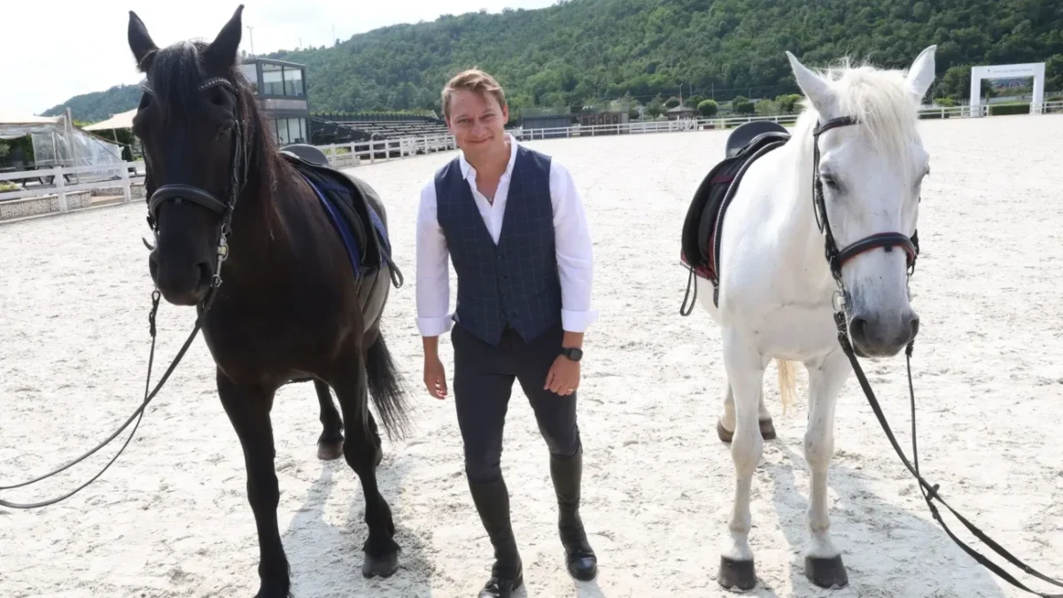 Natáčení seriálu O lidech a koních, muž stojí u koní.