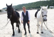 Natáčení seriálu O lidech a koních, muž stojí u koní.