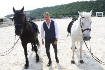 Natáčení seriálu O lidech a koních, muž stojí u koní.