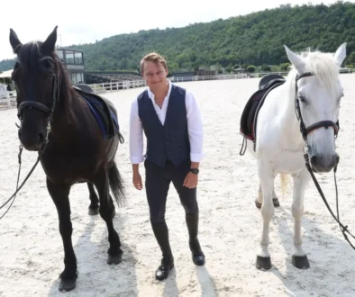 Natáčení seriálu O lidech a koních, muž stojí u koní.