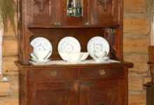 V regálu je vyskládané retro nádobí.