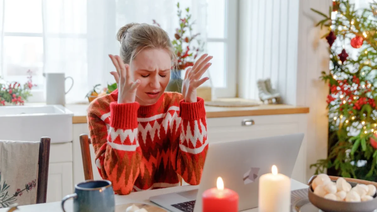 Žena sedí na Vánoce smutná u stolu.