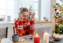 Žena sedí na Vánoce smutná u stolu.