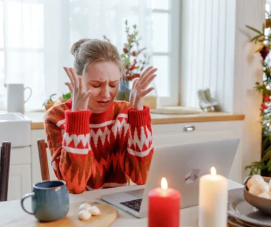 Žena sedí na Vánoce smutná u stolu.