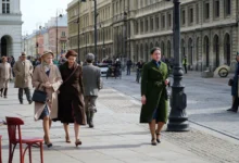 Dobově oblečené ženy se procházejí ulicemi.