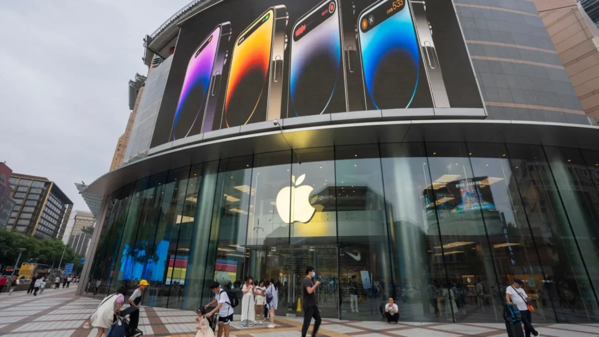 Před čínskou prodejnou Applu chodí lidé.