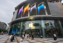 Před čínskou prodejnou Applu chodí lidé.