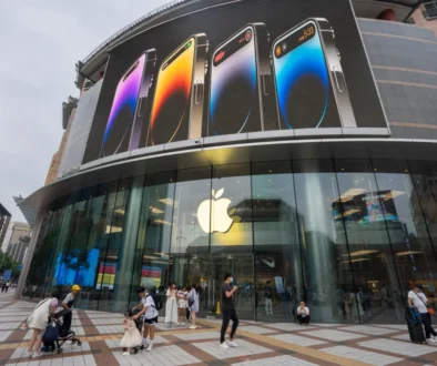 Před čínskou prodejnou Applu chodí lidé.