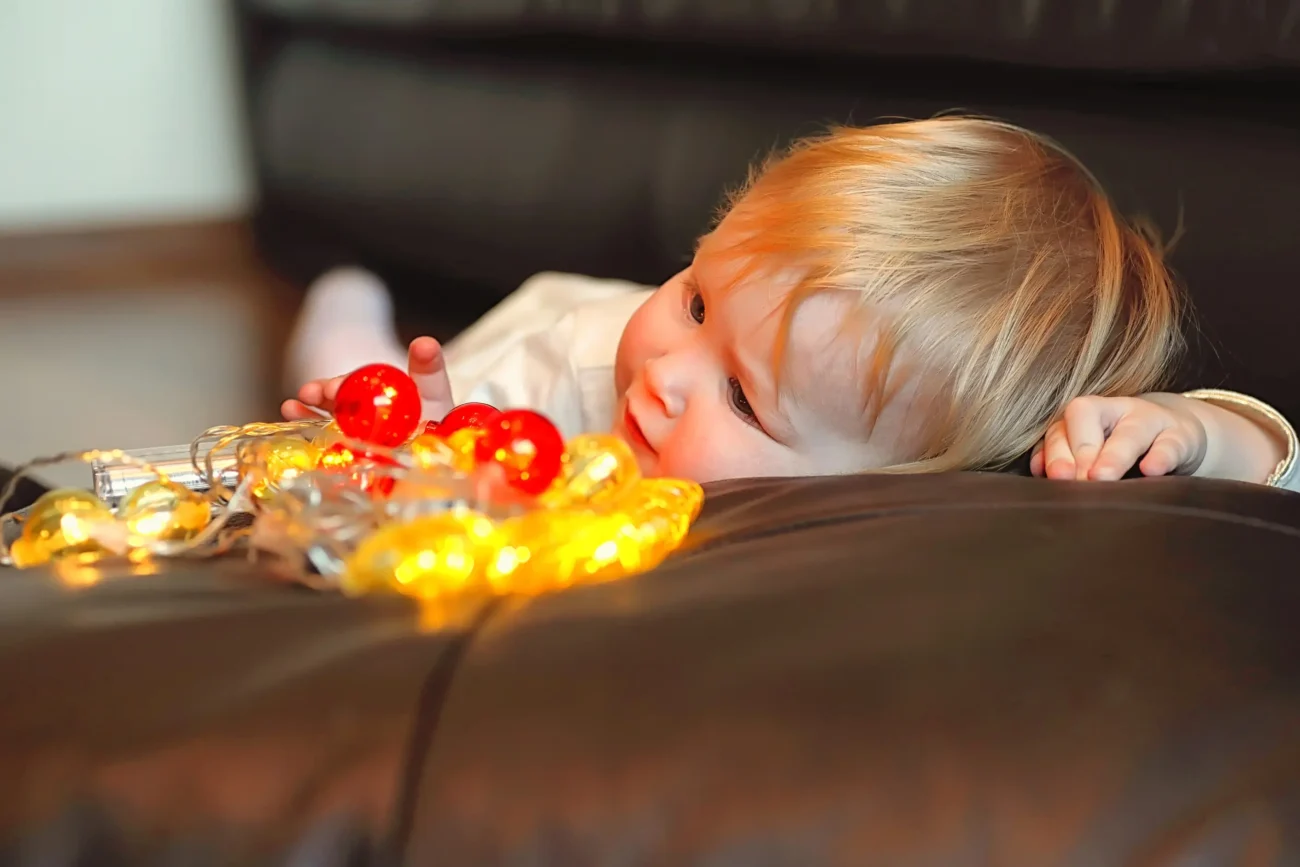 Chlapeček se společně se světýlky válí na gauči. 