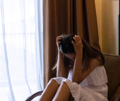 Žena sedí skleslá na křesle.