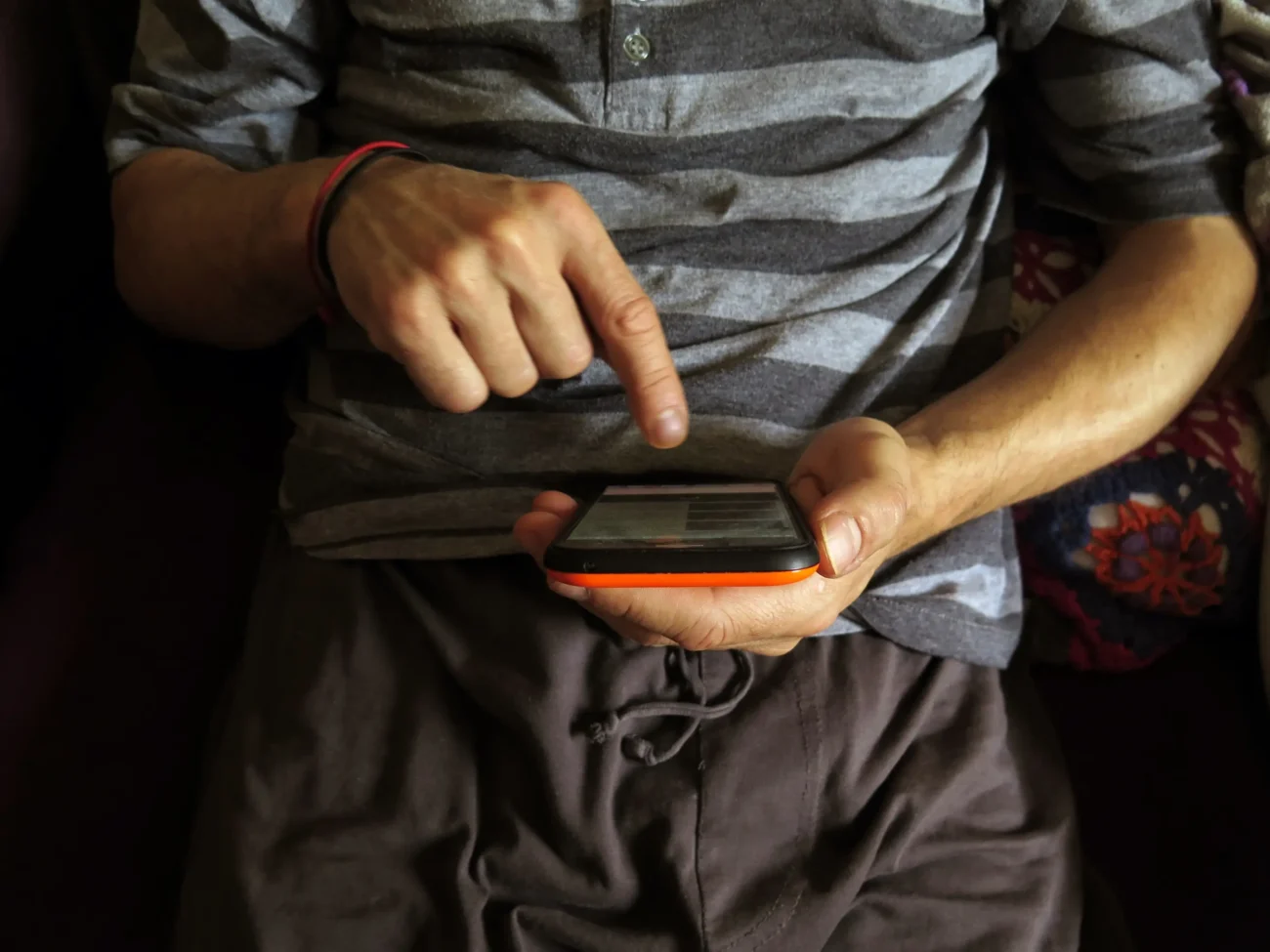 Člověk v ruce drží telefon a píše do něj. 