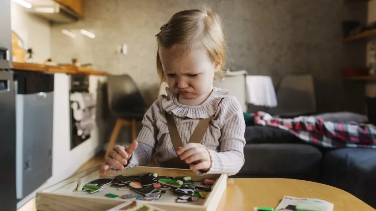 Holčička se tváří naštvaně u hračky.