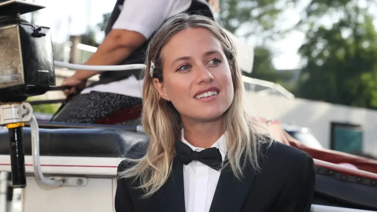 Emma Smetana stojí před autem a usmívá se.