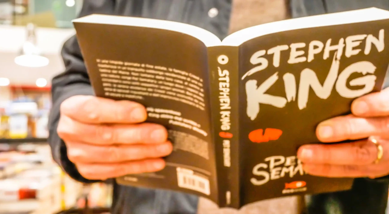 Člověk si čte knihu od Stephena Kinga.