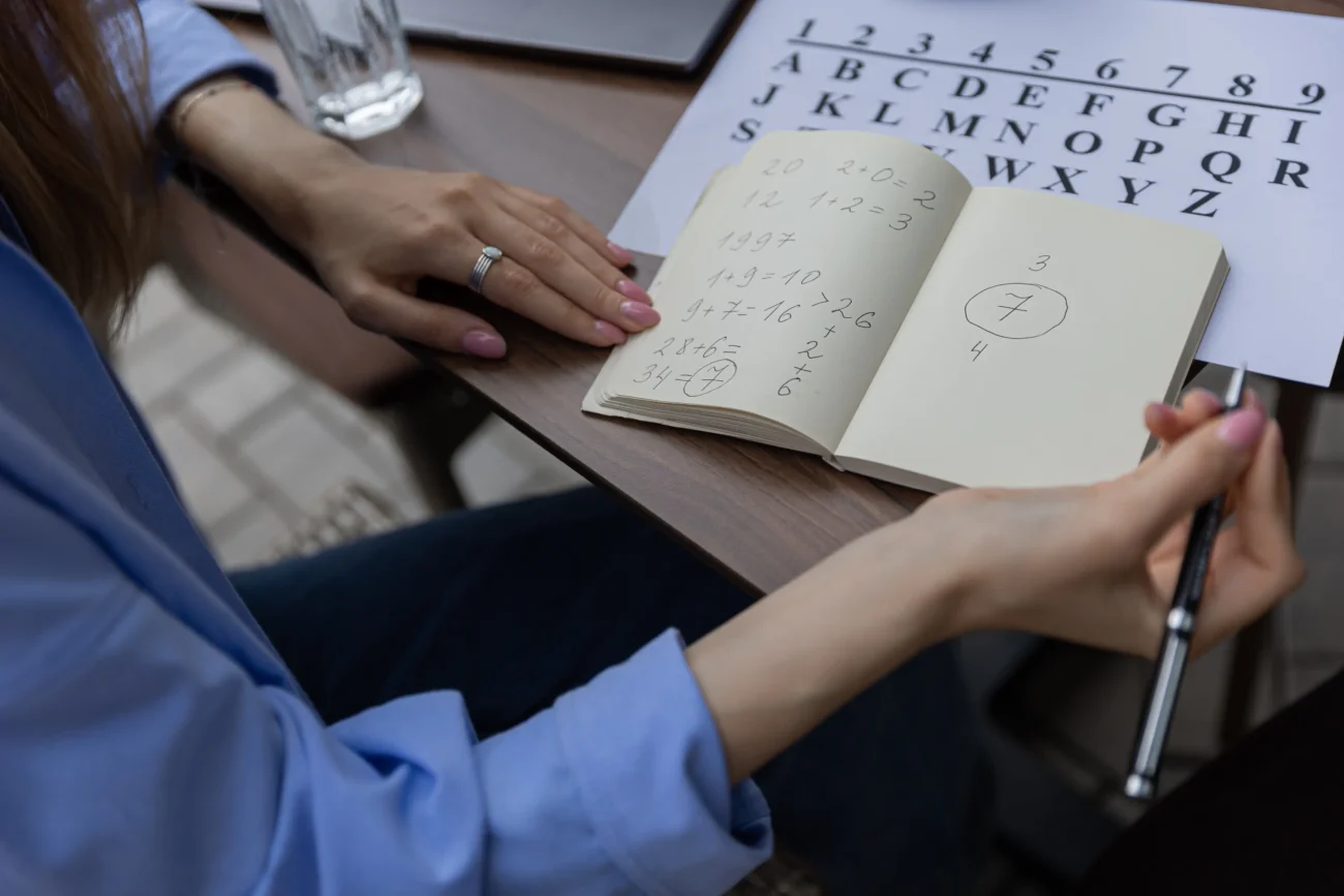 Žena si do sešitu zapisuje čísla.