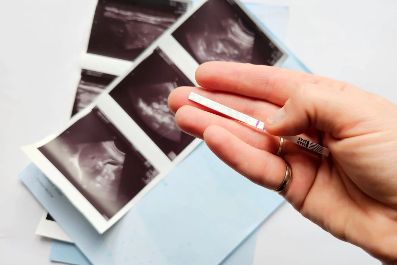 Žena v ruce drží těhotenský test. 