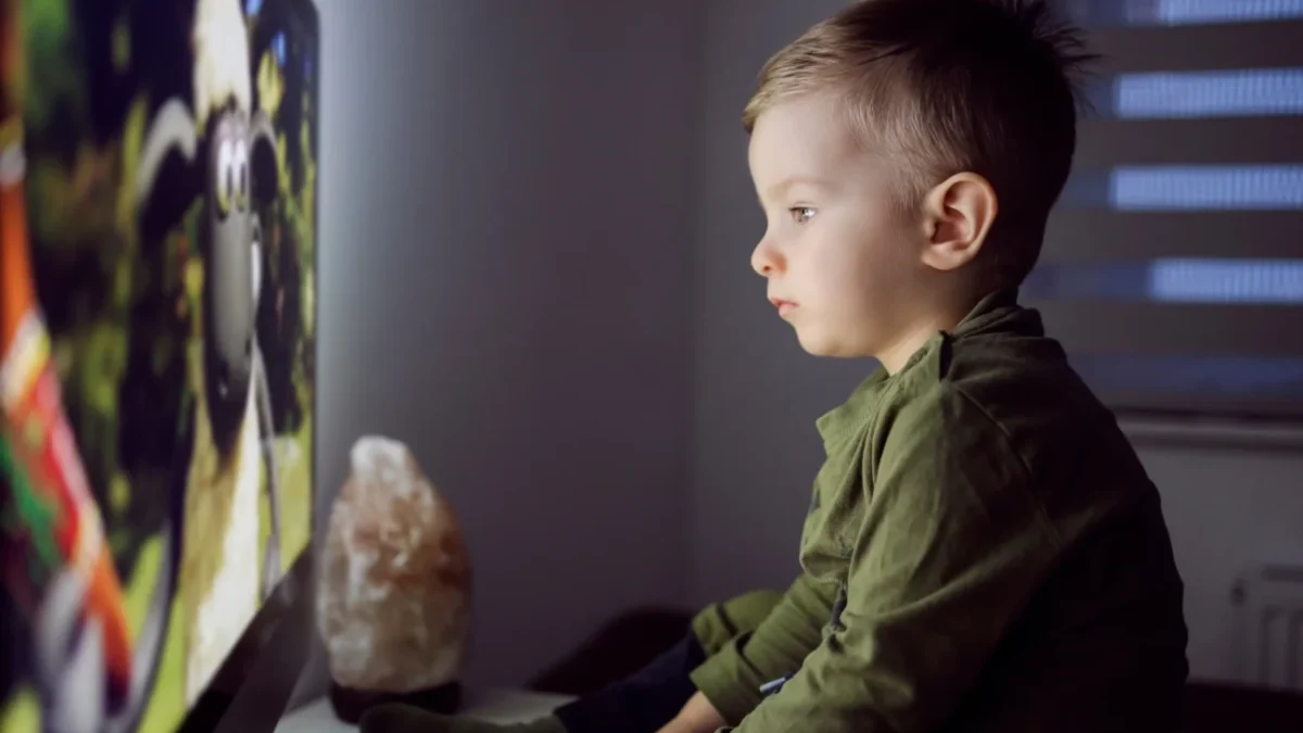 Chlapeček sedí před televizí.