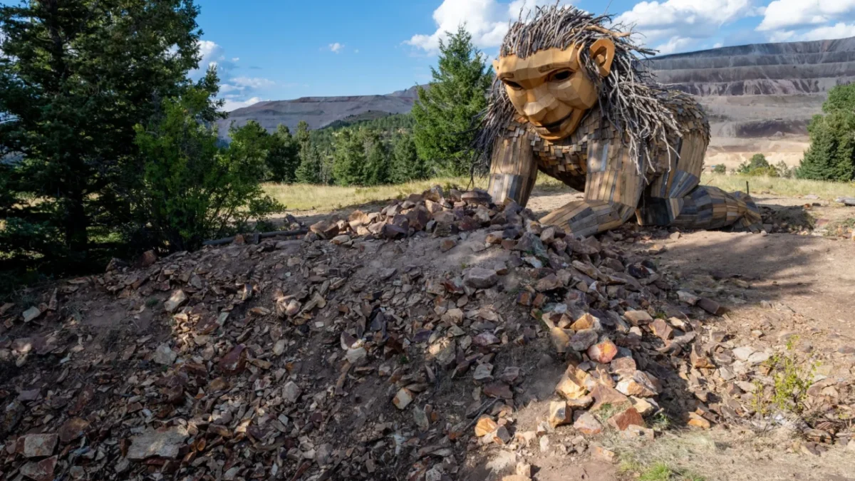 V přírodě je umístěná velká dřevěná socha.