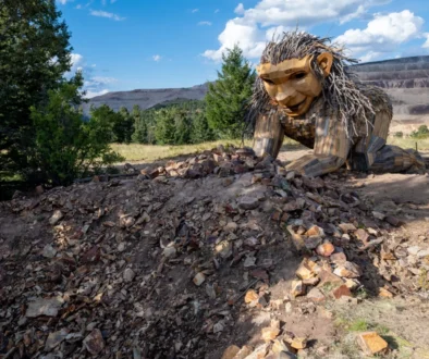 V přírodě je umístěná velká dřevěná socha.