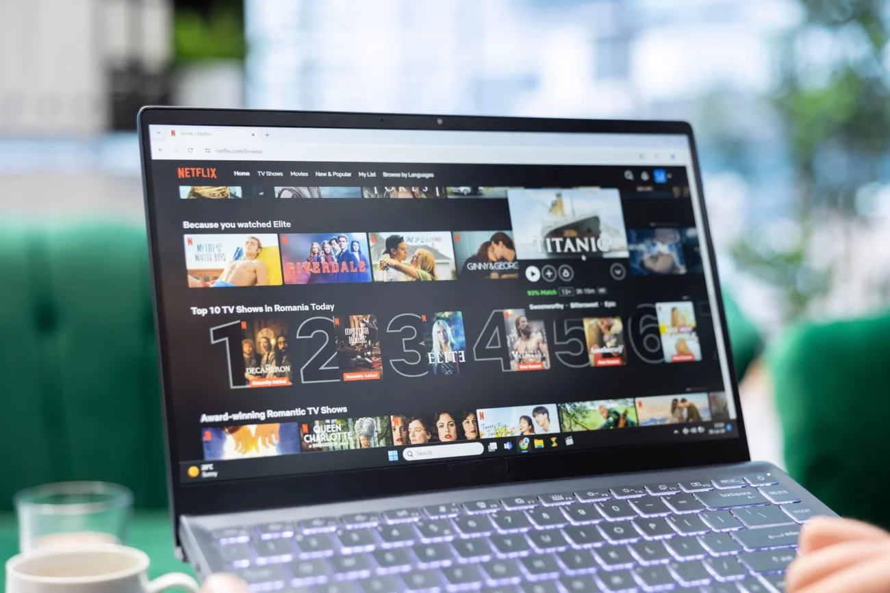 Na notebooku je spuštěná titulní strana Netflixu. 