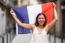 Žena nad hlavou drží francouzskou vlajku.