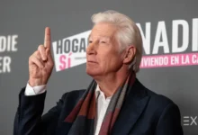 Richard Gere ukazuje prstem nahoru.