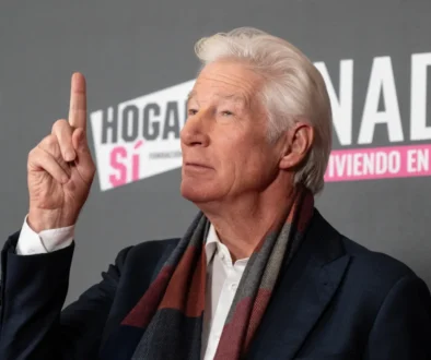 Richard Gere ukazuje prstem nahoru.