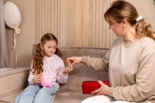 paní dává dceři drobné do kasičky