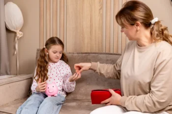 paní dává dceři drobné do kasičky