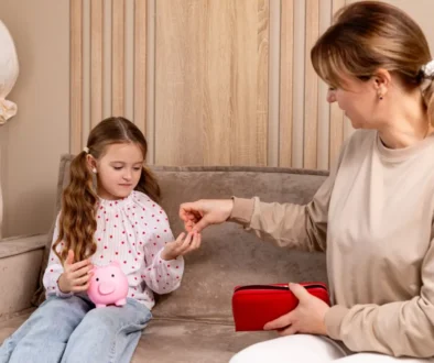 paní dává dceři drobné do kasičky