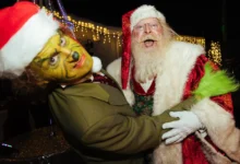 Muži v převleku Grinche a Santa Clause se objímají.