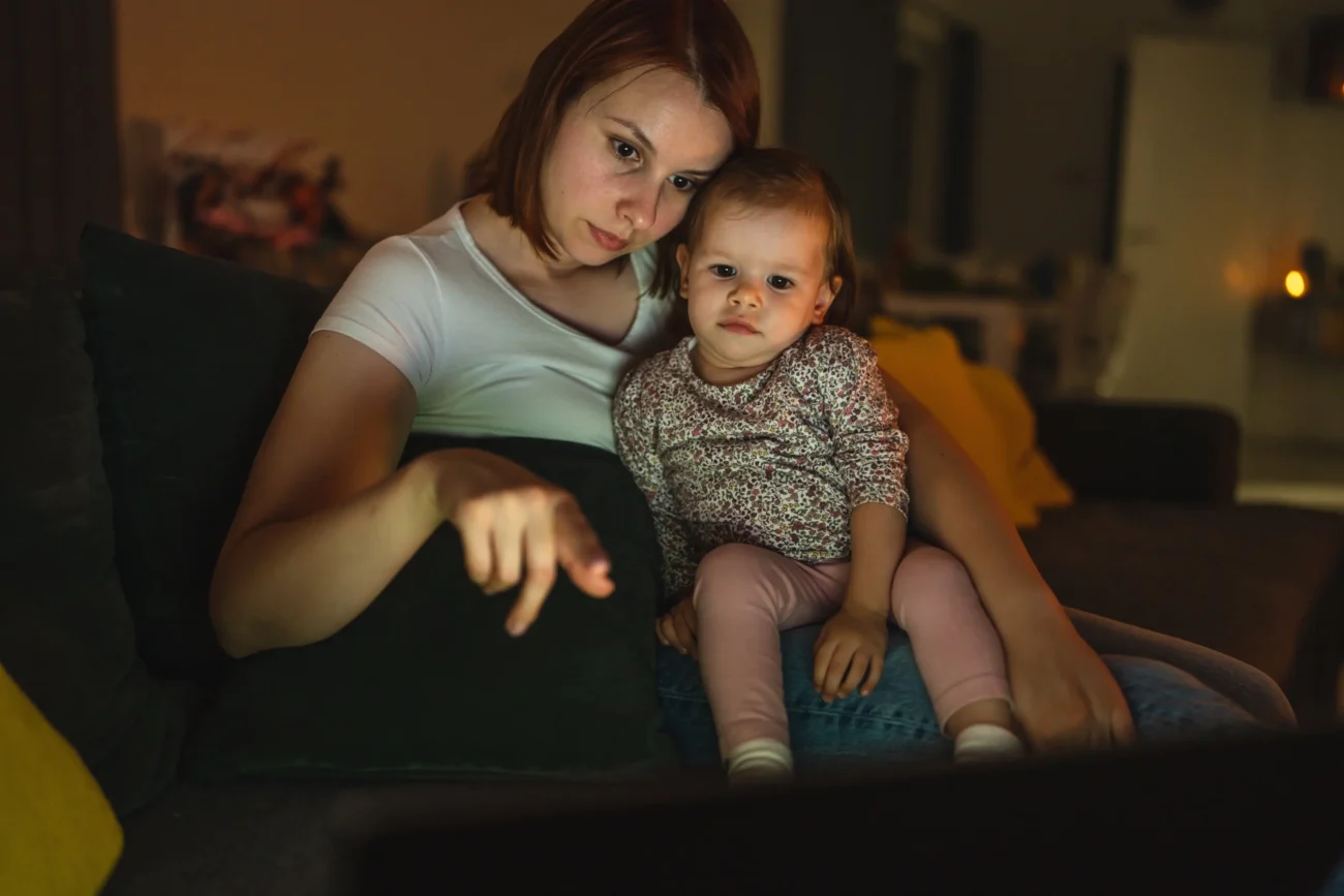 shutterstock_2182140379-2-2 | TVGURU.cz Žena s holčičkou sedí na gauči.