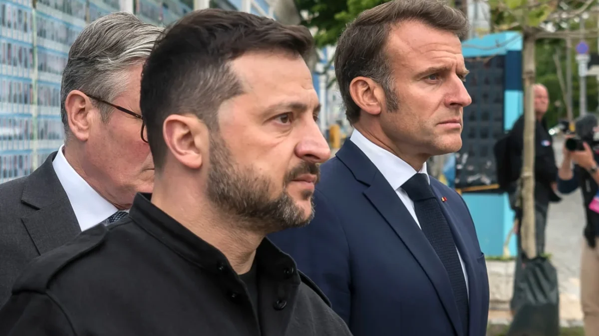 Volodymyr Zelenskyj stojí u dvou mužů.