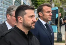 Volodymyr Zelenskyj stojí u dvou mužů.