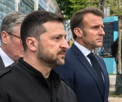 Volodymyr Zelenskyj stojí u dvou mužů.